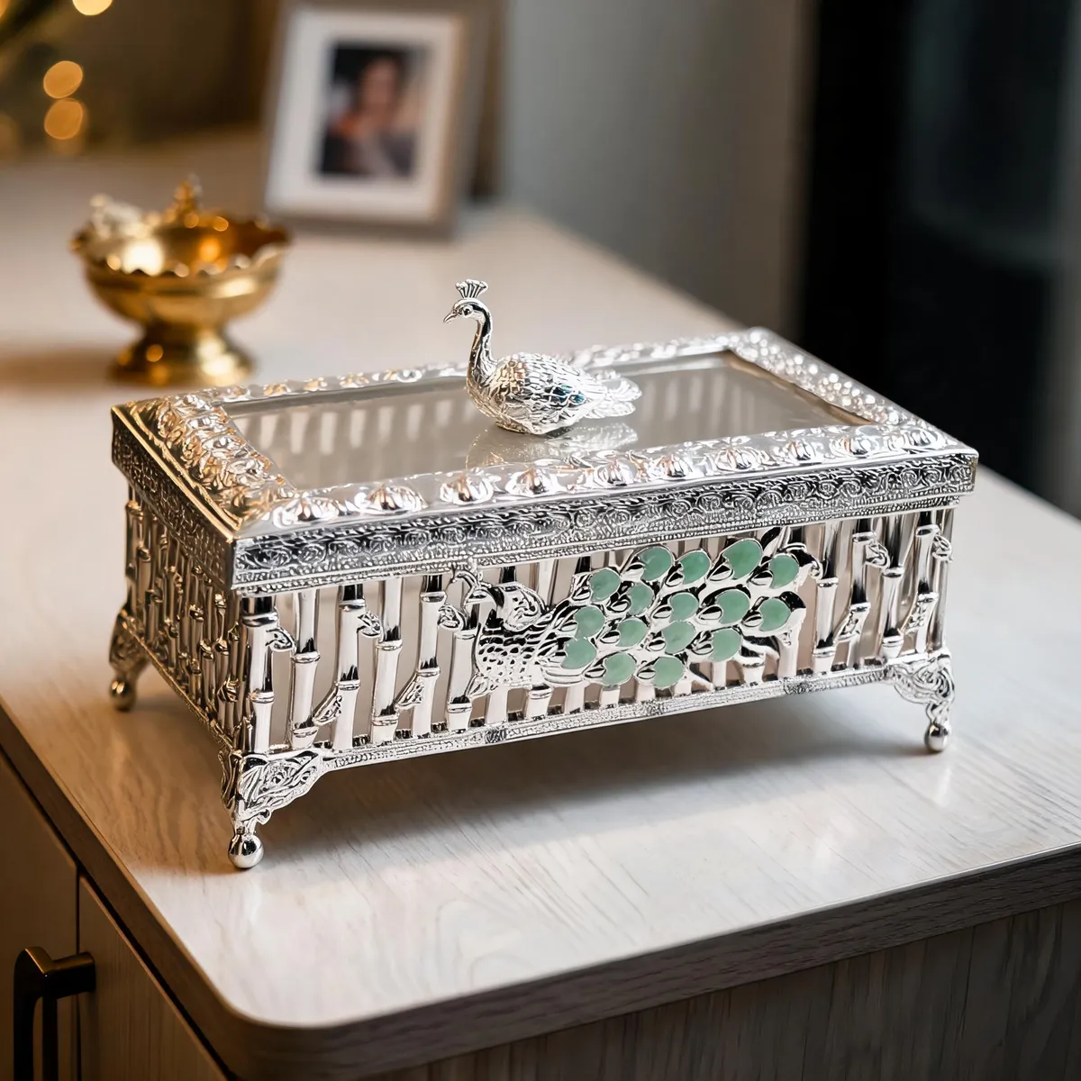 Silver casket with a peacock on its glass lid and green enamel panels