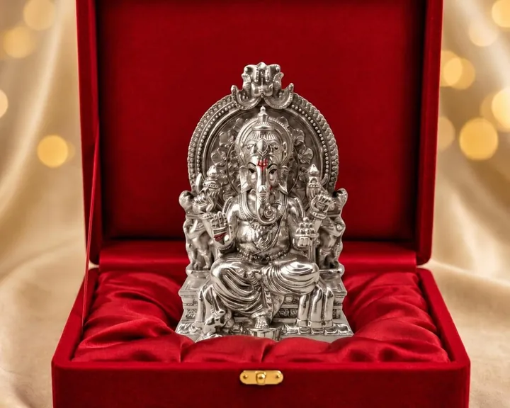 Silver Ganesh idol on a throne, presented in an open red velvet gift box