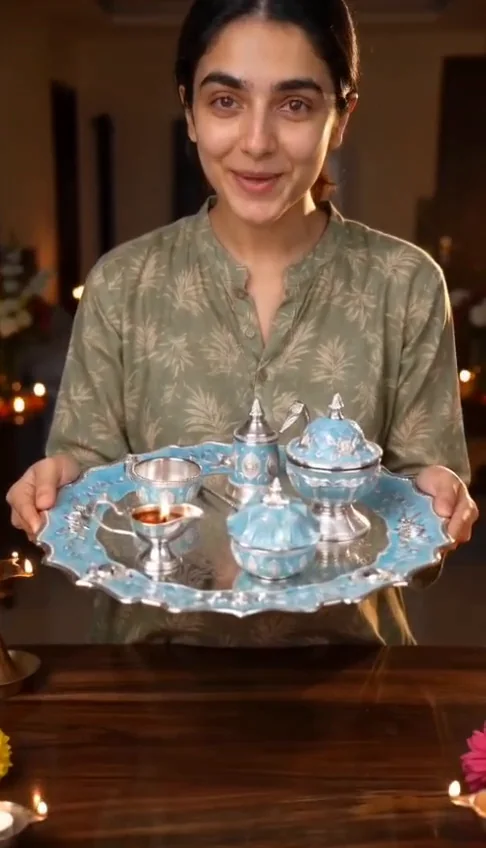 Woman presenting a teal and silver German Silver pooja thali